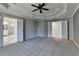Spacious primary bedroom with tray ceiling, fan, and neutral carpet at 1723 Woodbow Path, Dacula, GA 30019