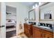 Bathroom with granite countertops, double sinks, wooden cabinets, and a view to the main bedroom at 350 Lamplighter Se Ln, Marietta, GA 30067