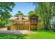 Back exterior elevation of the home with a wooden deck, patio, and lush landscaping at 350 Lamplighter Se Ln, Marietta, GA 30067