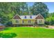 Inviting yellow home with green lawn and mature trees creates a picturesque curb appeal at 350 Lamplighter Se Ln, Marietta, GA 30067