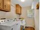 Bright laundry room featuring wood floors, overhead cabinets, and convenient washer and dryer at 4063 Penhurst Dr, Marietta, GA 30062