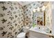Charming powder room with unique leaf-patterned wallpaper, a white vanity, and a toilet at 4063 Penhurst Dr, Marietta, GA 30062