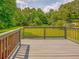 Wooden deck overlooking a spacious, grassy backyard with mature trees and greenery at 4601 Lindsey Dr, Powder Springs, GA 30127
