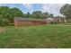 Manicured lawn with a charming single-story brick home and mature trees in the background at 4601 Lindsey Dr, Powder Springs, GA 30127