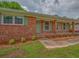 Close up of the red brick facade and front entrance with a painted green door and shutters at 4601 Lindsey Dr, Powder Springs, GA 30127