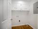 Functional laundry room with overhead cabinets, wood-look floors, and ample space at 4601 Lindsey Dr, Powder Springs, GA 30127