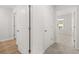 Hallway with hardwood-look flooring and carpeted bedroom beyond the white doors at 104 Crooked Lake Park, Villa Rica, GA 30180