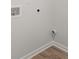 Laundry room with durable wood-look flooring and white walls with utility connections at 104 Crooked Lake Park, Villa Rica, GA 30180