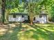 Backyard with a wooden deck, a well-maintained lawn, and mature trees providing shade at 4059 Big Valley Trl, Stone Mountain, GA 30083