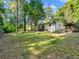 Spacious backyard with lush greenery, mature trees, and a view of the house with a wooden deck at 4059 Big Valley Trl, Stone Mountain, GA 30083