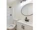 Bathroom with sleek fixtures, including a round mirror and a modern vanity with black hardware at 4059 Big Valley Trl, Stone Mountain, GA 30083