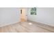 An airy bedroom with wood-look flooring, featuring a glimpse into an adjacent room through an open doorway at 4059 Big Valley Trl, Stone Mountain, GA 30083