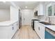 Updated kitchen featuring stainless steel appliances, white cabinets, modern fixtures, and new flooring at 4059 Big Valley Trl, Stone Mountain, GA 30083