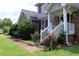 Charming porch entrance with white railings and colorful rose bushes, set against a brick facade at 4814 Delgado Dr Sw, Lilburn, GA 30047