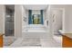 Bright bathroom featuring a large tub under a decorative glass window and a separate glass enclosed shower at 401 Riverwalk, Mcdonough, GA 30252