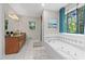 The bathroom has a tiled floor, granite countertop, and relaxing soaking tub with a backyard view at 401 Riverwalk, Mcdonough, GA 30252