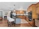 Spacious kitchen featuring wood cabinets, stainless steel appliances, granite counters, and a breakfast bar at 401 Riverwalk, Mcdonough, GA 30252