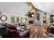 Open living room featuring a brick fireplace, vaulted ceilings, and wood floors with an abundance of natural light at 401 Riverwalk, Mcdonough, GA 30252