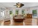 Comfortable living room showcasing hardwood floors, large windows, and cozy seating, ideal for Gathering gatherings at 401 Riverwalk, Mcdonough, GA 30252