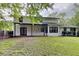 Charming backyard with covered patio, grassy yard, and a two-story home at 650 Lake Forest Ct, Roswell, GA 30076