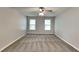 A spacious bedroom with neutral walls, ceiling fan, carpet, and natural light from the window at 650 Lake Forest Ct, Roswell, GA 30076
