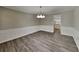 This dining room features wainscotting, new floors, a modern light fixture, and flows into the kitchen at 650 Lake Forest Ct, Roswell, GA 30076