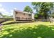 Spacious backyard with a deck, green lawn, lush landscaping, and a wooden privacy fence at 7000 Foxberry Ln, Roswell, GA 30075