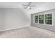 Bright bedroom featuring carpeted floor, a ceiling fan, and large windows at 7000 Foxberry Ln, Roswell, GA 30075