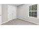 Cozy bedroom with plush carpet, natural light, and closet featuring double doors at 7000 Foxberry Ln, Roswell, GA 30075