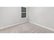 Neutral bedroom with plush carpet, a window for natural light and base molding at 7000 Foxberry Ln, Roswell, GA 30075
