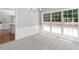 Bright dining space with plush carpeting, wainscoting detail, modern lighting, and large windows at 7000 Foxberry Ln, Roswell, GA 30075