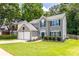 View of an attractive two-story house with a well-kept lawn, an attached two-car garage, and mature trees at 7000 Foxberry Ln, Roswell, GA 30075