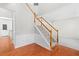 Bright foyer showcasing hardwood floors, elegant staircase with wood railing, and neutral walls at 7000 Foxberry Ln, Roswell, GA 30075