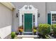 Elegant front door with decorative trim, flanked by sconces and planters with colorful flowers adding curb appeal at 7000 Foxberry Ln, Roswell, GA 30075