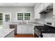Updated kitchen featuring white cabinets, granite countertops, a gas range and stainless steel dishwasher at 7000 Foxberry Ln, Roswell, GA 30075