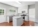 Open kitchen with an island, stainless steel appliances, granite countertops, and white cabinets at 7000 Foxberry Ln, Roswell, GA 30075