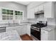 Modern kitchen with white cabinets, granite countertops, stainless steel appliances, and a gas range at 7000 Foxberry Ln, Roswell, GA 30075