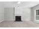 Bright living room with fireplace, ceiling fan, neutral carpeting and large windows providing natural light at 7000 Foxberry Ln, Roswell, GA 30075