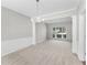 Bright living room with plush carpet, wainscoting, modern chandelier, and natural light from large window at 7000 Foxberry Ln, Roswell, GA 30075