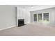 Cozy living room featuring a classic fireplace, neutral carpet, and large windows for plenty of natural light at 7000 Foxberry Ln, Roswell, GA 30075