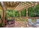 Back deck featuring an outdoor seating area, a wood pergola, a wooded view, and ample space at 120 Timbervalley Ln, Lawrenceville, GA 30043