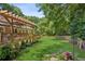 Expansive backyard featuring a wooden pergola, lush lawn, and a charming stone pathway at 120 Timbervalley Ln, Lawrenceville, GA 30043