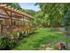 Expansive backyard featuring a lush lawn, a wooden deck, and mature trees at 120 Timbervalley Ln, Lawrenceville, GA 30043
