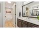Bathroom with brown cabinets, a large framed mirror, and a separate soaking tub at 120 Timbervalley Ln, Lawrenceville, GA 30043