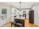 Bright kitchen featuring an island, white cabinets, granite counters, subway tile backsplash, and stainless steel appliances at 120 Timbervalley Ln, Lawrenceville, GA 30043