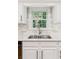 Kitchen sink and window with white cabinets, white subway tile backsplash, and granite countertops at 120 Timbervalley Ln, Lawrenceville, GA 30043