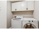 Bright Laundry Room featuring front load washer and dryer with white cabinets above at 120 Timbervalley Ln, Lawrenceville, GA 30043