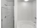 Bright bathroom featuring a glass door shower, a separate tub, and neutral color scheme at 2438 Suwanee Pointe Dr, Lawrenceville, GA 30043