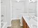 Bathroom with double sinks, wood cabinet and shower-tub combo at 2438 Suwanee Pointe Dr, Lawrenceville, GA 30043
