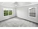 A bright, spacious bedroom featuring plush carpet, a tray ceiling with fan, and ample natural light at 2438 Suwanee Pointe Dr, Lawrenceville, GA 30043